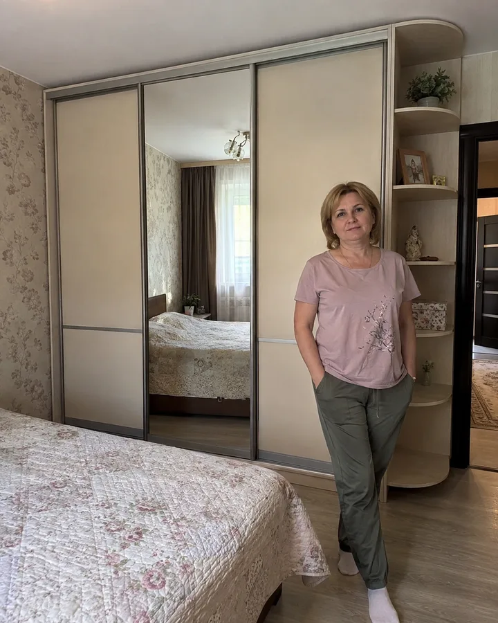 Заказчица рядом со шкафом-купе с зеркалом и открытыми полками