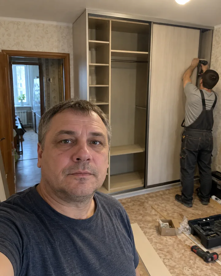 Заказчик и монтажник во время установки раздвижной двери шкафа